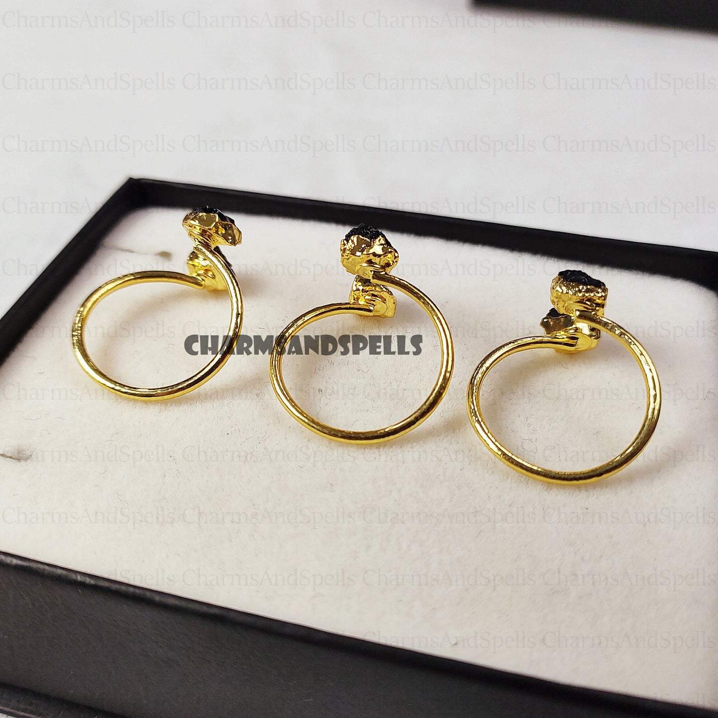 Gold-plated, adjustable rings featuring raw black tourmaline gemstones. The rings showcase the natural, unpolished texture of the black tourmaline crystals. These unique, handmade gemstone rings are ideal as protection jewelry, unique gifts for women, or a statement piece for bohemian, spiritual, or earthy styles. The black tourmaline offers grounding and protective energies. These electroplated raw black tourmaline rings are perfect for those seeking a raw crystal and metaphysical benefits.